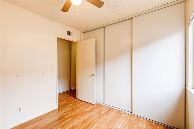 23719 White Owl Ct, Moreno Valley, CA 92553 - unfurnished bedroom featuring light wood finished floors, a closet, ceiling fan, and a textured ceiling