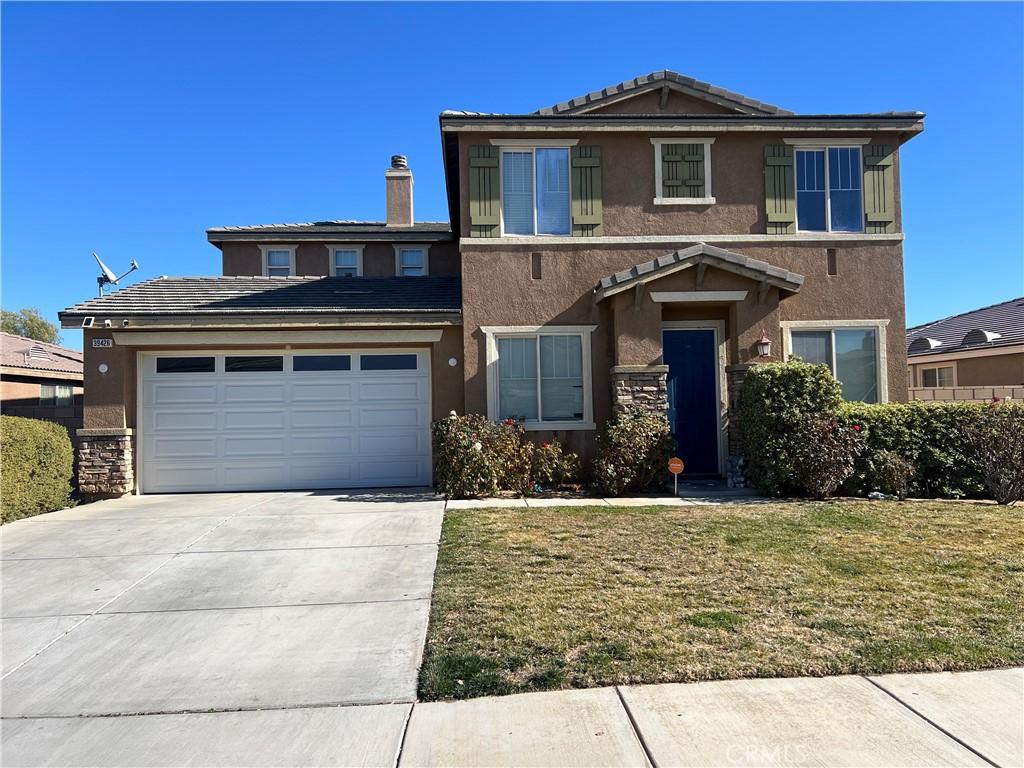 39426 Oxford Rd, Palmdale, CA 93551 - traditional-style home featuring stucco siding, driveway, an attached garage, and a front lawn