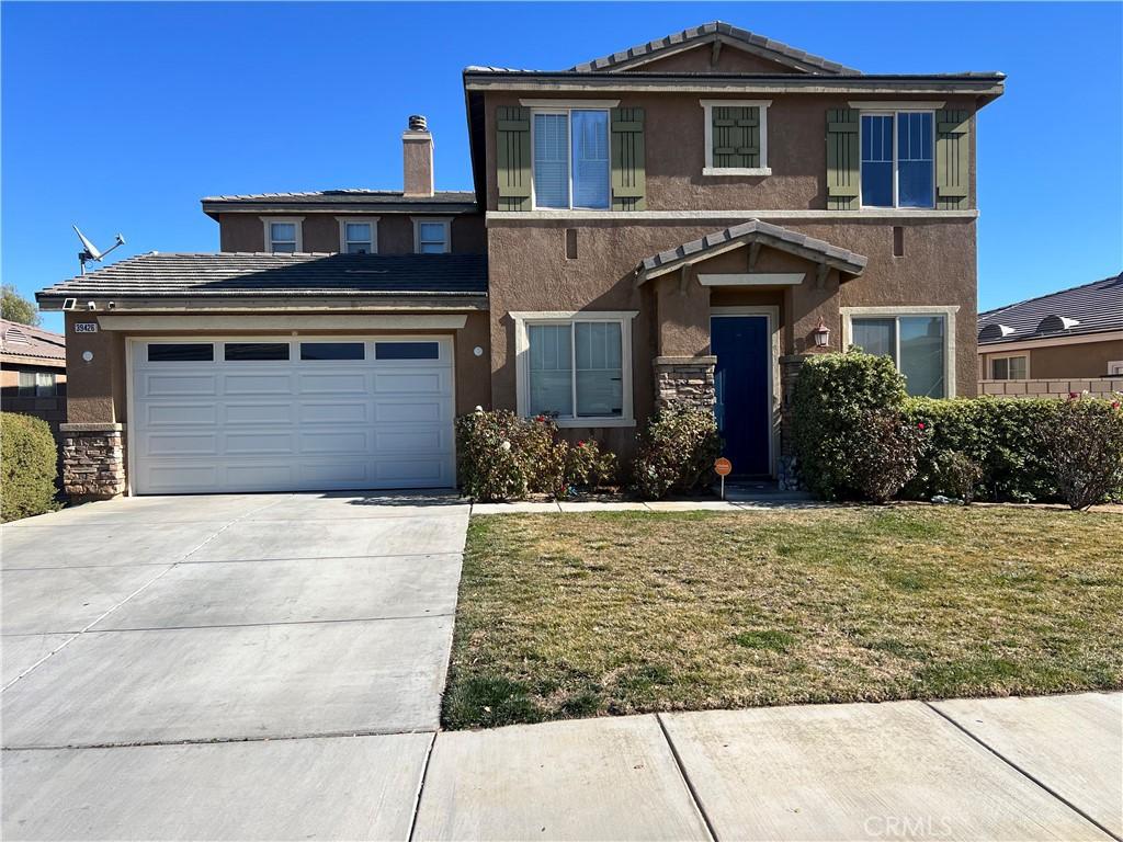 39426 Oxford Rd, Palmdale, CA 93551 - view of front of home with stucco siding, driveway, a garage, a front lawn, and a tile roof