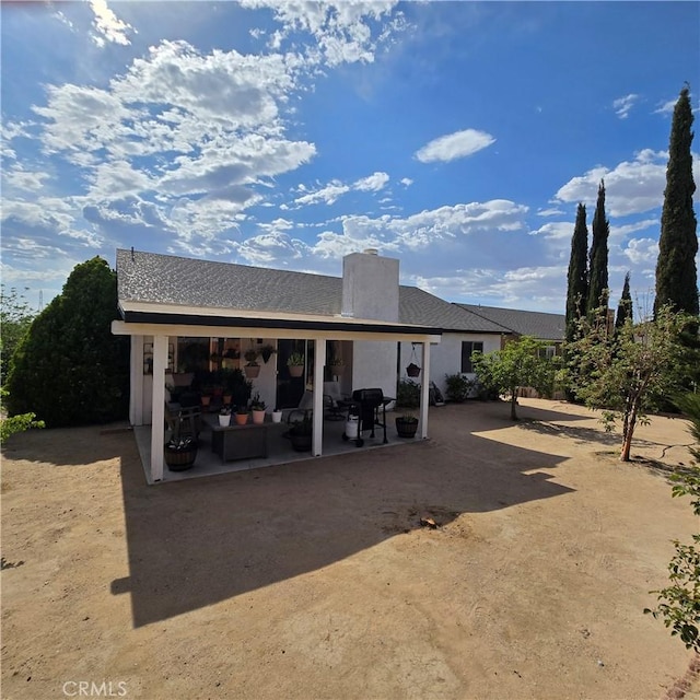 17795 Stevens Rd, Adelanto, CA 92301 - back of house featuring a patio, a chimney, and an outdoor living space