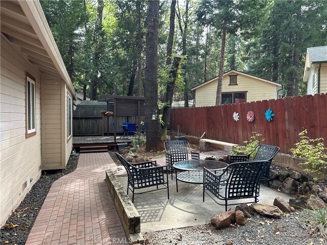 14749 Vassar Ct, Magalia, CA 95954 - view of patio featuring a deck, a fenced backyard, and outdoor dining space