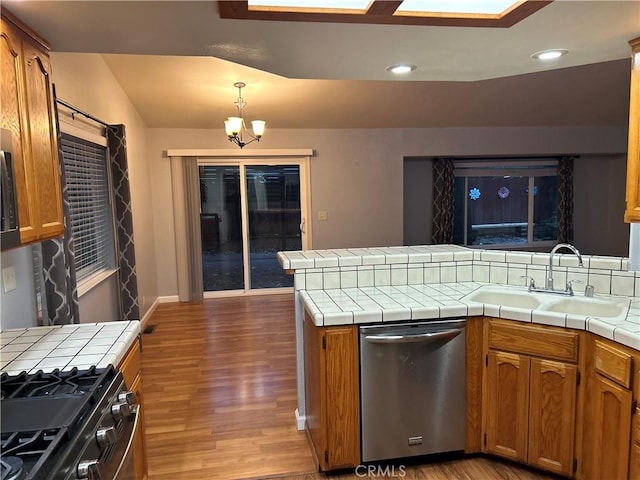 14749 Vassar Ct, Magalia, CA 95954 - kitchen with stainless steel dishwasher, a sink, tile countertops, range with gas cooktop, and wood finished floors