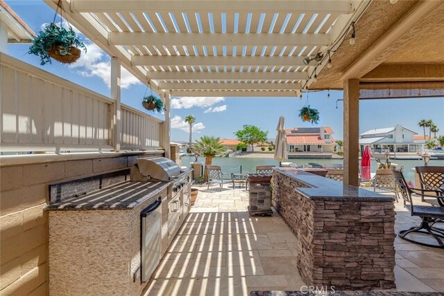 13545 Anchor Dr, Victorville, CA 92395 - view of patio with area for grilling, a pergola, a water view, and exterior bar