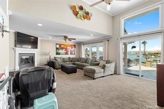 13545 Anchor Dr, Victorville, CA 92395 - carpeted living room featuring a ceiling fan, ornamental molding, a glass covered fireplace, a water view, and recessed lighting