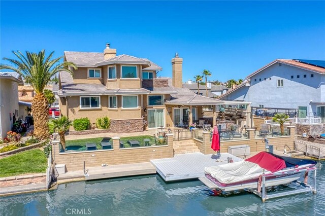 13545 Anchor Dr, Victorville, CA 92395 - back of house with stucco siding, a chimney, a patio area, and a water view