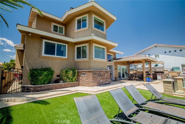 13545 Anchor Dr, Victorville, CA 92395 - rear view of property featuring stucco siding, a patio area, and a gate