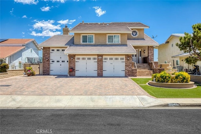 13545 Anchor Dr, Victorville, CA 92395 - view of front of property featuring driveway, stucco siding, a chimney, and brick siding