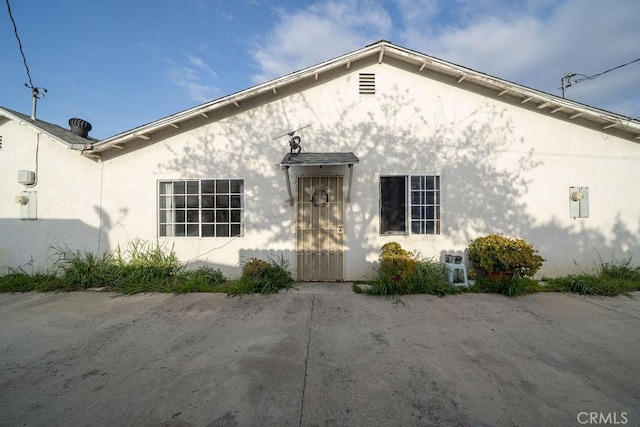 back of property featuring stucco siding
