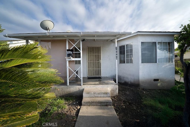 view of exterior entry featuring stucco siding