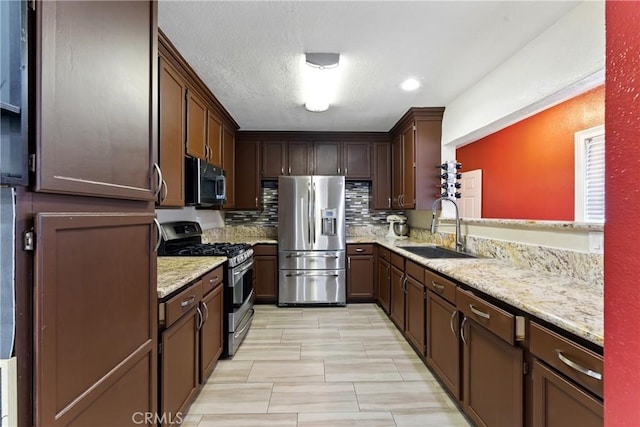 1933 W 147th St, Gardena, CA 90249 - kitchen featuring appliances with stainless steel finishes, a sink, tasteful backsplash, light stone counters, and dark brown cabinets