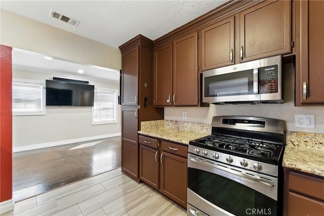 1933 W 147th St, Gardena, CA 90249 - kitchen featuring stainless steel appliances, baseboards, light stone countertops, and light wood-type flooring