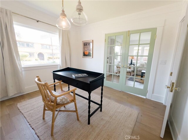office featuring french doors, healthy amount of natural light, and light wood-style floors