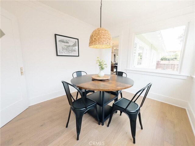 dining space with light wood-style floors and baseboards