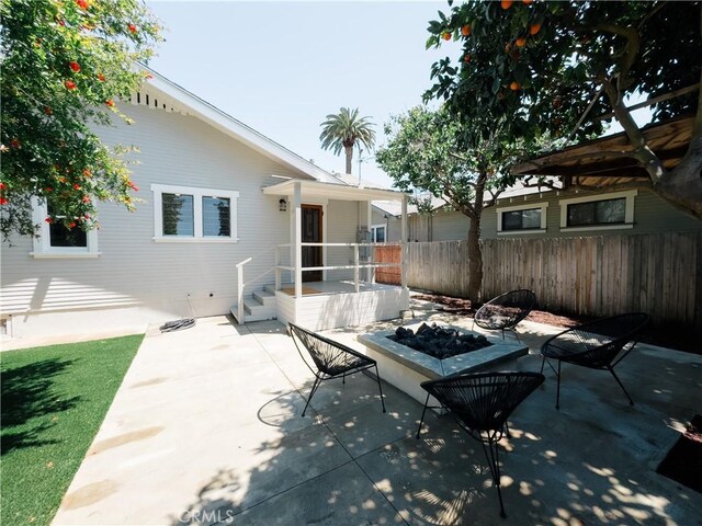 view of patio / terrace featuring a fire pit and fence