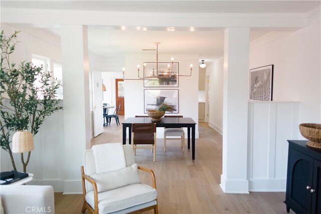 sitting room with a chandelier, light wood-style floors, and baseboards
