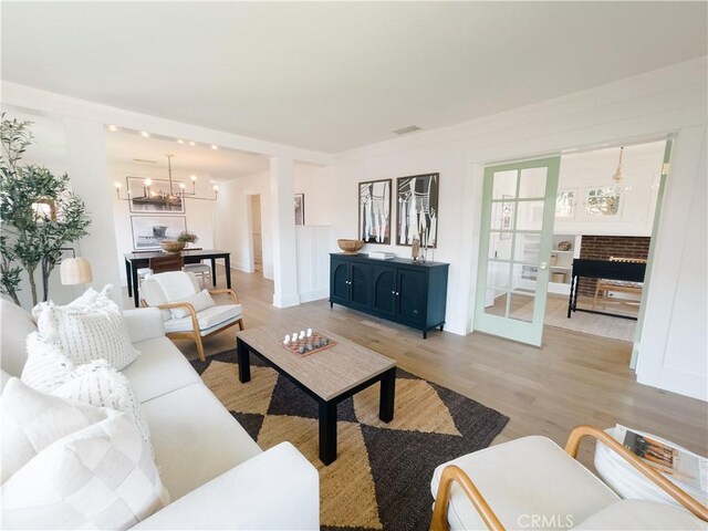 living area with light wood finished floors and a chandelier