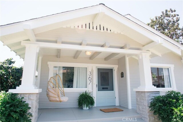 view of exterior entry featuring covered porch