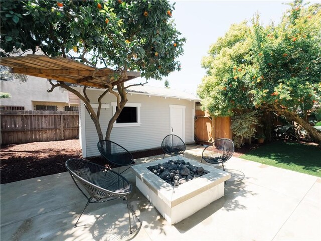 view of patio / terrace featuring fence and a fire pit