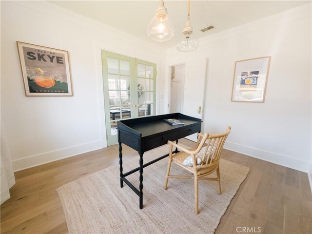 home office featuring light wood-style floors, baseboards, and french doors