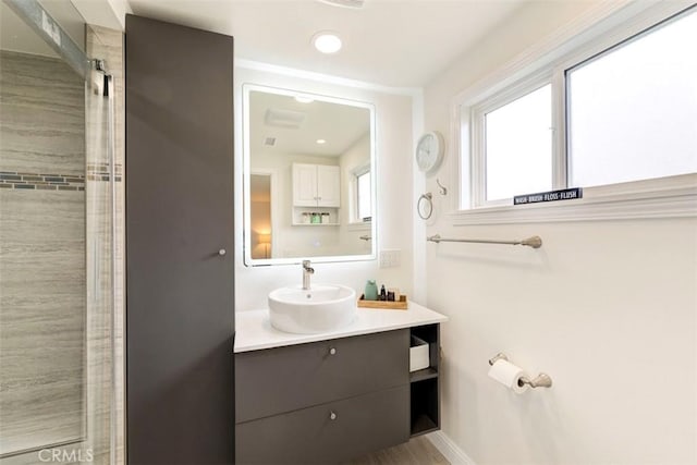 full bathroom featuring vanity, recessed lighting, a shower, and baseboards