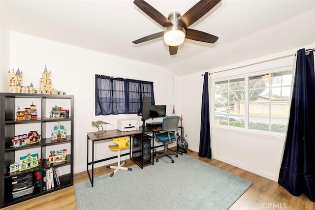 office area featuring a ceiling fan, wood finished floors, baseboards, and lofted ceiling