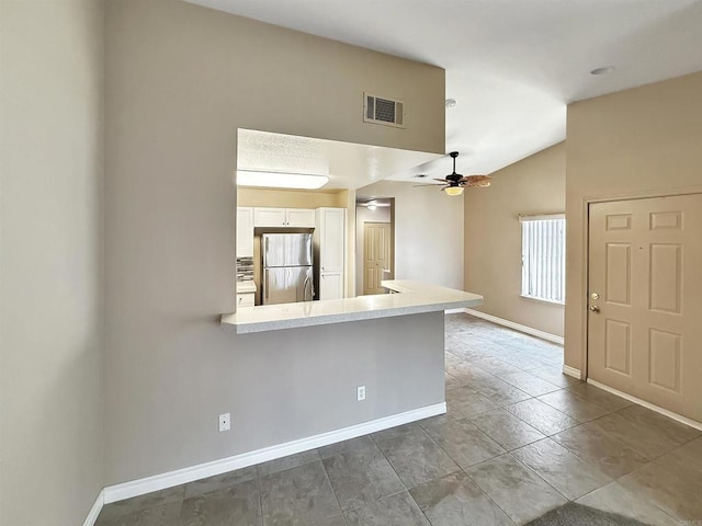 1074 Merrill Cir, Hemet, CA 92545 - kitchen with freestanding refrigerator, white cabinets, lofted ceiling, light countertops, and baseboards