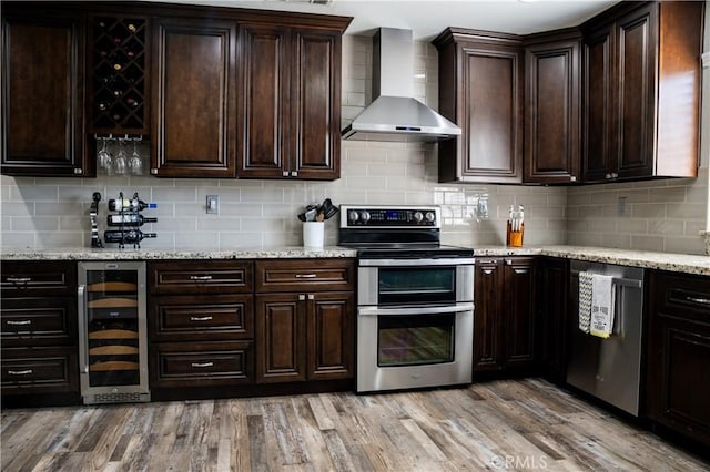 6338 Countryside Ct, Orland, CA 95963 - kitchen featuring wall chimney range hood, beverage cooler, appliances with stainless steel finishes, tasteful backsplash, and dark brown cabinetry