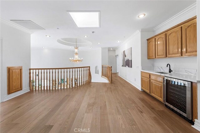 2638 Highridge Dr, Chino Hills, CA 91709 - bar area with beverage cooler, ornamental molding, a sink, a chandelier, and light wood-type flooring