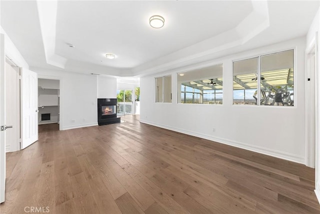 2638 Highridge Dr, Chino Hills, CA 91709 - unfurnished living room with a tray ceiling, wood-type flooring, baseboards, and a multi sided fireplace