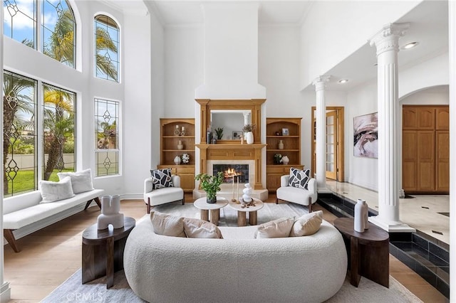 2638 Highridge Dr, Chino Hills, CA 91709 - living area featuring a towering ceiling, ornate columns, plenty of natural light, crown molding, and a tiled fireplace