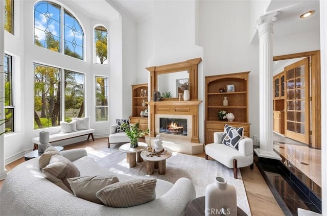2638 Highridge Dr, Chino Hills, CA 91709 - living area with decorative columns, plenty of natural light, a high ceiling, a glass covered fireplace, and ornamental molding