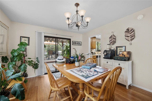 dining space featuring a chandelier, plenty of natural light, and light wood-style flooring