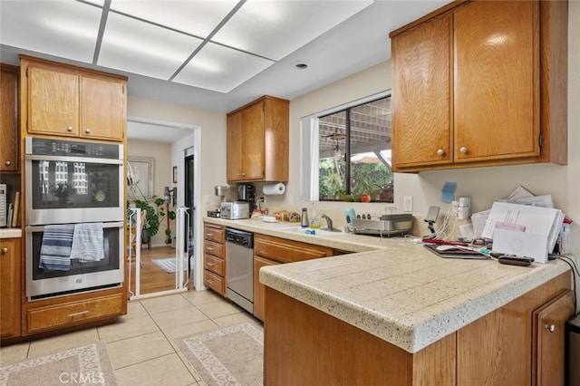 kitchen with stainless steel appliances, light countertops, and light tile patterned floors