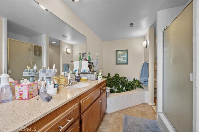 bathroom with a stall shower, vanity, and stone finish flooring