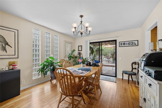 dining room featuring a chandelier, light wood-style flooring, and baseboards