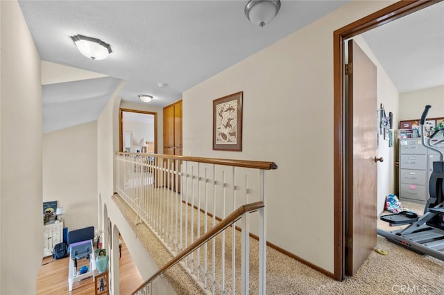 hallway with an upstairs landing and baseboards