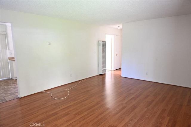 25258 Taylor St, Loma Linda, CA 92354 - unfurnished room featuring a heating unit, wood finished floors, and baseboards
