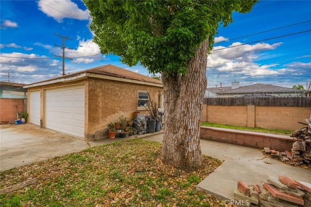 6016 Wilson Ave, South Gate, CA 90280 - view of home's exterior with fence, an outdoor structure, a garage, and stucco siding