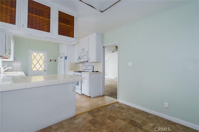6016 Wilson Ave, South Gate, CA 90280 - kitchen featuring white appliances, tile countertops, white cabinets, a sink, and baseboards