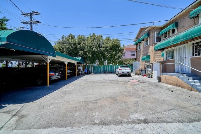 1023 S Wilton Pl, Los Angeles, CA 90019 - partially covered parking lot featuring fence