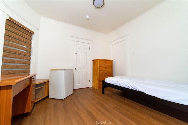 1023 S Wilton Pl, Los Angeles, CA 90019 - bedroom with light wood-style flooring, freestanding refrigerator, and ornamental molding
