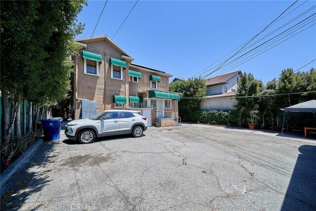 1023 S Wilton Pl, Los Angeles, CA 90019 - view of front of property featuring uncovered parking, brick siding, and fence