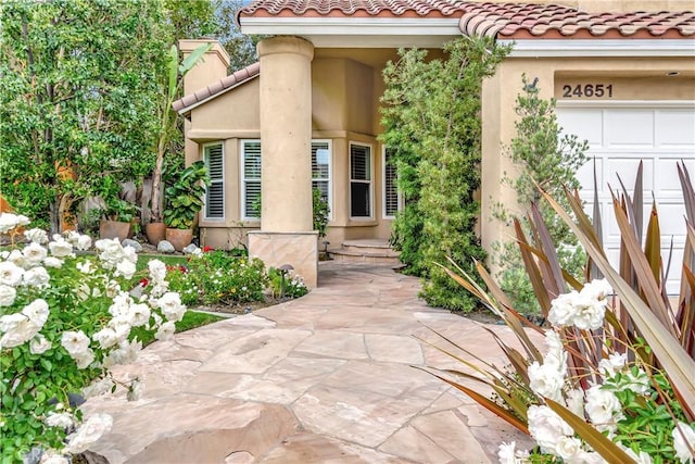 property entrance featuring a tiled roof and stucco siding