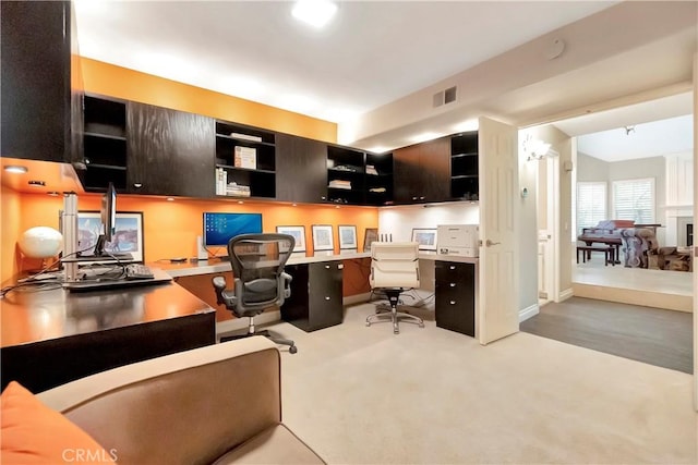 carpeted office space with built in desk