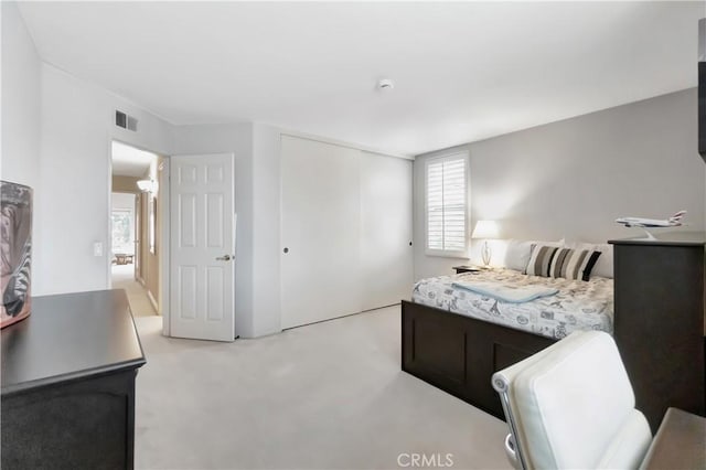 bedroom featuring a closet and light colored carpet