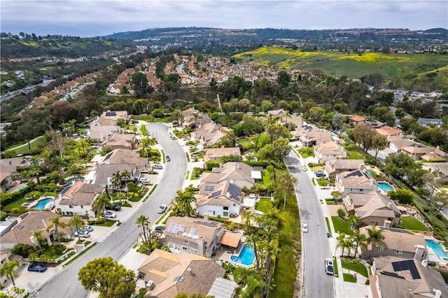 aerial view of property and surrounding area featuring nearby suburban area and a pool
