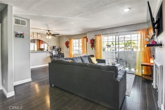 13580 Foothill Blvd Unit 1, Sylmar, CA 91342 - living area with baseboards, a textured ceiling, a ceiling fan, dark wood-style flooring, and arched walkways