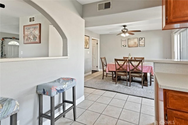 13580 Foothill Blvd Unit 1, Sylmar, CA 91342 - dining area featuring a ceiling fan, light tile patterned floors, arched walkways, and baseboards