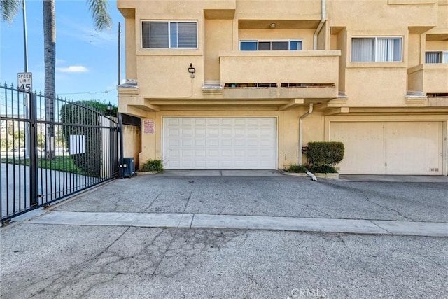 13580 Foothill Blvd Unit 1, Sylmar, CA 91342 - view of front of house with stucco siding, concrete driveway, an attached garage, and fence