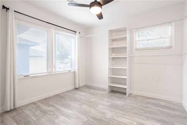 unfurnished bedroom with light wood finished floors, baseboards, and a ceiling fan